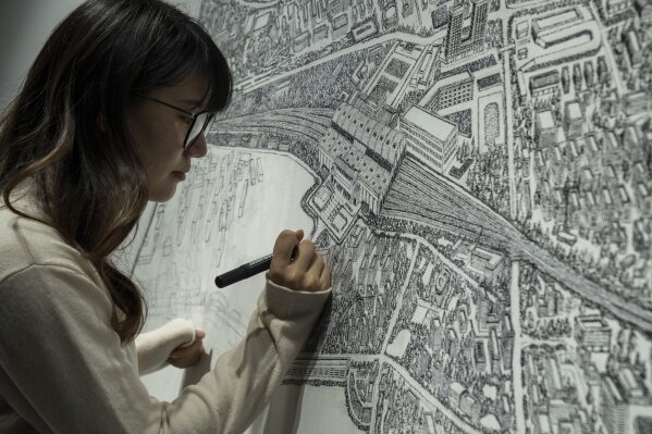 Chinese artist Yang Qian using dots to recreate an aerial view of Wuhan, China, under lockdown at her studio in Wuhan in central China's Hubei province on Sunday, Jan. 24, 2021. Yang, who worked as a volunteer delivering vital supplies to hospitals and residents during the city's pandemic 76-day lockdown, is using her art work to make sure that history is not forgotten. (AP Photo/Ng Han Guan)