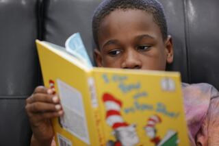Michael Crowder, 11, reads during an after-school literacy program in Atlanta on Thursday, April 6, 2023. Michael missed most of first grade, the foundational year for learning to read. It was the first fall of the pandemic, and for months Atlanta only offered school online. Michael's mom had just had a baby, and there was no quiet place to study in their small apartment. He missed a good part of second grade, too. (AP Photo/Alex Slitz)