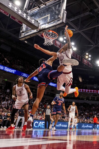 South Carolina guard Arden Conyers (21) is fouled by Auburn center Dylan Cardwell (44) as he shoots during the second half of an NCAA college basketball game on Saturday, Jan. 11, 2025, in Columbia, S.C. (AP Photo/Scott Kinser)