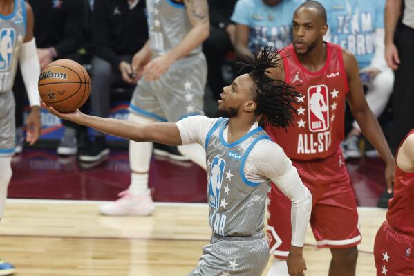 Cleveland Cavalier Darius Garland, left, puts up a shot during the first half of the NBA All-Star basketball game, Sunday, Feb. 20, 2022, in Cleveland. (AP Photo/Ron Schwane)
