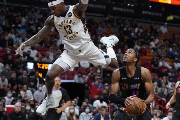 Indiana Pacers forward Torrey Craig (13) leaps over Miami Heat forward KZ Okpala (11) as Okpala attempts a shot during the second half of an NBA basketball game, Tuesday, Dec. 21, 2021, in Miami. (AP Photo/Wilfredo Lee)