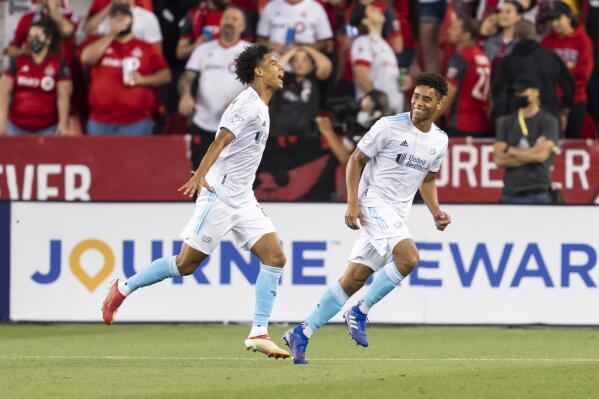 New England Revolution's Tajon Buchanan, left, celebrates with Brandon Bye after Buchanan scored during the first half of an MLS soccer match against Toronto FC on Saturday, Aug. 14, 2021, in Toronto. (Mark Blinch/The Canadian Press via AP)