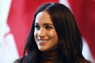 FILE - In this Tuesday, Jan. 7, 2020 file photo, Meghan, Duchess of Sussex smiles during her visit with Prince Harry to Canada House, in London. Buckingham Palace said Wednesday, March 3, 2021 it was launching an investigation after a newspaper reported that a former aide had made a bullying allegation against the Duchess of Sussex. The Times of London reported allegations that the duchess drove out two personal assistants and left staff feeling “humiliated.” (Daniel Leal-Olivas/Pool Photo via AP, file)