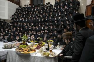 FILE - Ultra-Orthodox Jews of the Sadigura Hasidic dynasty celebrate the Jewish feast of 'Tu Bishvat' or "New Year of the Trees." as they sit with their rabbis around a long table filled with all kinds of fruits, in the ultra-Orthodox town of Bnei Brak, Israel, Sunday, Jan. 16, 2022. In April 2022, the country's communications minister made it easier for the Haredi, or ultra-Orthodox, community, to use the devices without the knowledge of their rabbis, raising tensions within the Haredi community and between them and the rest of Israeli society. (AP Photo/Ariel Schalit, File)