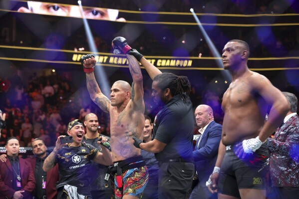 UFC light heavyweight champion Alex Pereira is announced as the winner over Jamahal Hill after their title fight during the UFC 300 mixed martial arts event Saturday, April 13, 2024, in Las Vegas. (Steve Marcus/Las Vegas Sun via AP)