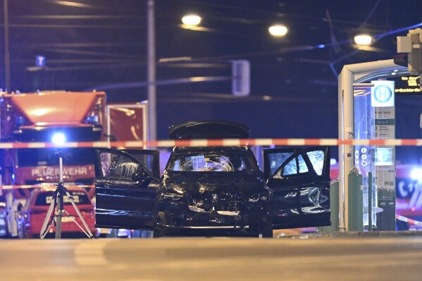 A damaged car sits with its doors open after a driver plowed into a busy Christmas market in Magdeburg, Germany, early Saturday, Dec. 21, 2024. (Hendrik Schmidt/dpa via AP)