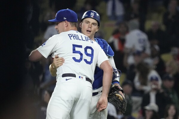 Los Angeles Dodgers relief pitcher Evan Phillips, left, and catcher Will Smith congratulate each other after the Dodgers defeated the San Francisco Giants 7-2 in a baseball game Thursday, Sept. 21, 2023, in Los Angeles. (AP Photo/Mark J. Terrill)