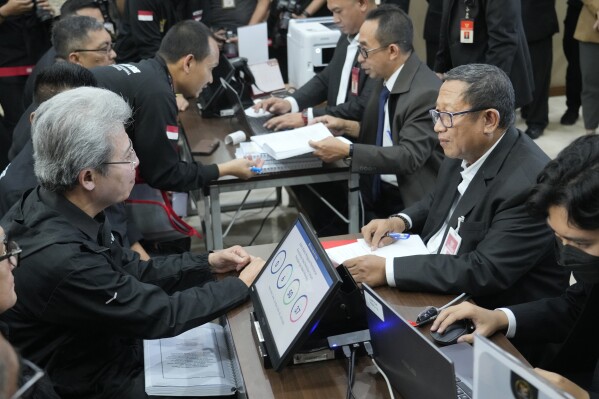 Todung Mulya Lubis, left, a prominent Indonesian lawyer representing losing presidential candidate Ganjar Pranowo registers a legal challenge alleging widespread irregularities and fraud in Feb. 14 presidential election, at the Constitutional Court in Jakarta, Indonesia, Saturday, March 23, 2024. The election winner, Defense Minister Prabowo Subianto, received more than 96 million votes, or 58.6%. He was accused of human rights abuses under a past dictatorship and chose the son of the popular outgoing president as his running mate. (AP Photo/Achmad Ibrahim)