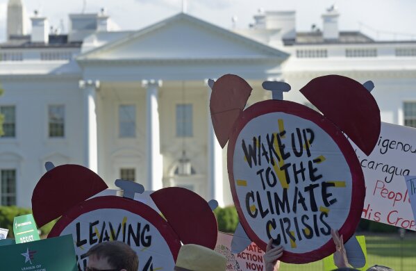 
              FILE - In this June 1, 2017 file photo, protesters gather outside the White House in Washington to protest President Donald Trump's decision to withdraw the Unites States from the Paris climate change accord. Environmental activists are ramping up a pressure campaign aimed at stoking Democratic support for an ambitious environmental plan known as the Green New Deal ahead of the 2020 presidential race.  (AP Photo/Susan Walsh)
            