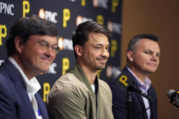 Pittsburgh Pirates Bryan Reynolds, center, celebrates signing a contact extension through the 2030 baseball season with general manager Ben Cherrington, right, and Pirates owner Bob Nutting, during a meeting with reporters in Pittsburgh, Wednesday, April 26, 2023. (AP Photo/Gene J. Puskar)