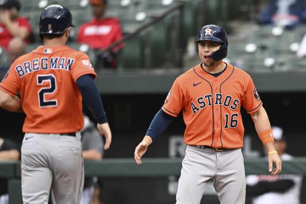 Houston Astros' Aledmys Diaz, right, greets Alex Bregman, left, after they cored on a single by Christian Vasquez against the Baltimore Orioles in the 11th inning of a baseball game, Sunday, Sept. 25, 2022, in Baltimore. (AP Photo/Gail Burton)