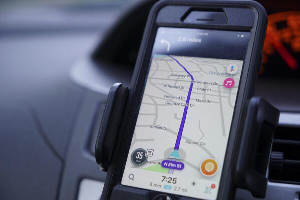 FILE - Former police data analyst Davin Hall uses the Waze navigation app while driving through Greensboro, N.C., on Wednesday, June 22, 2022. Hall quit the city's police force in part over its use of Fog Reveal, a powerful cellphone-tracking tool that the company says uses data from apps like Waze to track mobile devices. (AP Photo/Allen G. Breed, File)