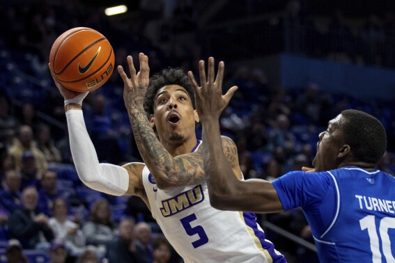 FILE - James Madison guard Terrence Edwards Jr. (5) shoots against Georgia State forward Jay'Den Turner (10) during the first half of an NCAA college basketball game in Harrisonburg, Va., Thursday, Feb. 15, 2024. James Madison’s Terrence Edwards says his team has been dealing with pressure ever since it stunned the college basketball world with a season-opening upset of then-No. 4 Michigan State. Edwards and the Dukes are hoping it enables them to make a similar impact on March Madness.(Daniel Lin/Daily News-Record via AP, File, File)