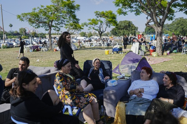 People talk as they sit on sofas during Israel's Independence Day celebrations at a park in Tel Aviv, Tuesday, May 14, 2024. Israelis are marking 76 years since Israel's creation. (AP Photo/Ohad Zwigenberg).