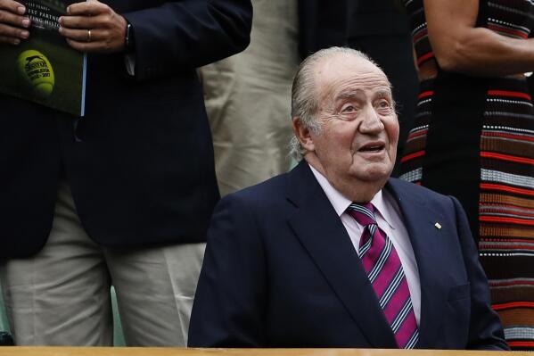 FILE - Former Spanish King Juan Carlos takes his seat for the Women's Singles final match between Venus Williams of the United States and Spain's Garbine Muguruza on day twelve at the Wimbledon Tennis Championships in London, on  July 15, 2017.  Geneva prosecutors have fined a Swiss bank for failing to alert money laundering authorities about millions in funds from Saudi Arabia that went to former Spanish King Juan Carlos and his ex-lover, but have dropped any charges against his associates in the case. (AP Photo/Kirsty Wigglesworth, File)