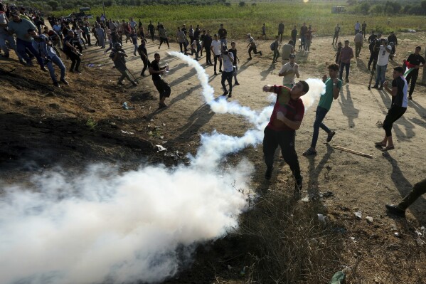 Palestinian protesters clash with Israeli security forces along the frontier with Israel during a demonstration marking Israel's withdrawal from Gaza in 2005, east of Gaza City, Wednesday, Sept. 13, 2023. Activists said at least four people were killed in an explosion. The Israeli army said the blast took place when protesters tried to throw explosives over the fence. (AP Photo/Adel Hana)