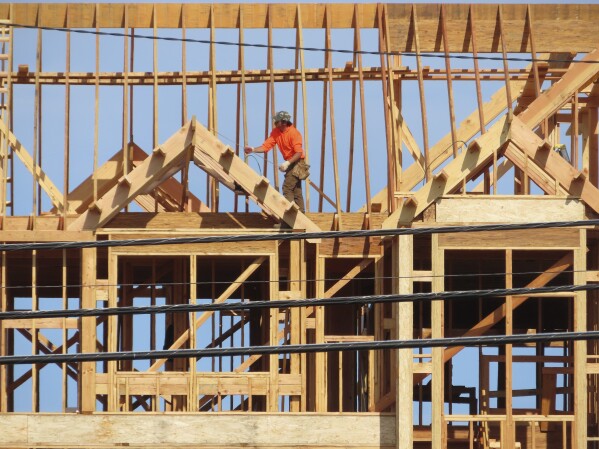A construction worker examines part of a building under construction in Brick, N.J. on July 10, 2023. (AP Photo/Wayne Parry, File)