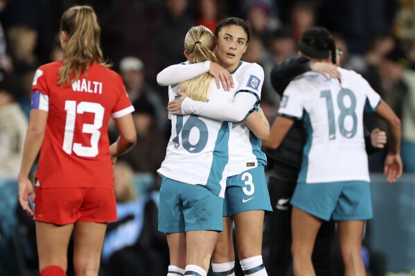 New Zealand's Claudia Bunge, right, and New Zealand's Jacqui Hand embrace after the Women's World Cup Group A soccer match between New Zealand and Switzerland in Dunedin, New Zealand, Sunday, July 30, 2023. (AP Photo/Matthew Gelhard)