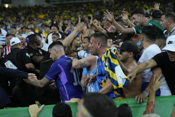 Brazilian and Argentinian fans fight in the stands prior to a qualifying soccer match for the FIFA World Cup 2026 between Brazil and Argentina at Maracana stadium in Rio de Janeiro, Brazil, Tuesday, Nov. 21, 2023. (AP Photo/Silvia Izquierdo)