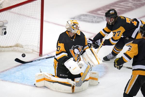 Pittsburgh Penguins' Jeff Carter (77) cannot block a rebounding puck from going across the goal line behind Penguins goaltender Louis Domingue (70) for the winning goal by New York Rangers' Chris Kreider during the third period in Game 6 of an NHL hockey Stanley Cup first-round playoff series in Pittsburgh, Friday, May 13, 2022. (AP Photo/Gene J. Puskar)