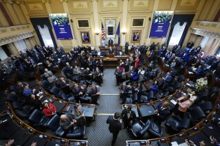 FILE - Virginia Gov. Glenn Youngkin, bottom center, arrives in the House chambers to deliver his State of the Commonwealth address at the Capitol, Jan. 10, 2024, in Richmond, Va. The Democratic-controlled Virginia Senate and House of Delegates on Thursday, Feb. 22, each passed their own proposed version of the next two-year state budget, documents lawmakers will start to work from to fashion a compromise spending plan to send to Republican Gov. Glenn Youngkin. (AP Photo/Steve Helber, file)