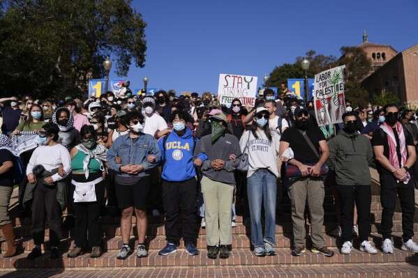 Demonstrators lock arms on the UCLA campus, after nighttime clashes between Pro-Israel and Pro-Palestinian groups, Wednesday, May 1, 2024, in Los Angeles. (AP Photo/Jae C. Hong)