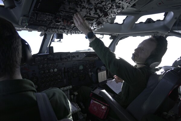The pilot of a French military AWACS surveillance plane operates cockpit equipment on a 10-hour mission Tuesday, Jan. 9, 2024, to eastern Romania for the NATO military alliance. France's four E-3 Sentry AWACS aircraft are based on a modified Boeing 707 airframe. The pilot, who could only be identified by his rank and first name, Major Kevin, said commercial pilots sometimes express envy about him flying 707s, which first flew in 1957. Boeing 707s stopped flying passengers commercially in 2013. (AP Photo/John Leicester)