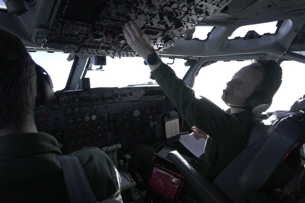 The pilot of a French military AWACS surveillance aircraft operates cockpit instruments on a 10-hour mission for the NATO military alliance in eastern Romania, Tuesday, Jan. 9, 2024.  France's four E-3 Sentry AWACS aircraft are based on modified Boeing 707 airframes.  The pilot, who could only be identified by his rank and first name, Major Kevin, said commercial pilots sometimes express jealousy about him flying the 707, which first flew in 1957.  The Boeing 707 stopped flying passengers commercially in 2013.  (AP Photo/John Leicester)