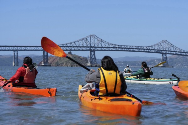 A delegation of Indigenous leaders from Ecuador kayak in the San Francisco Bay to take a closer look at the Chevron Long Wharf, Thursday, June 19, 2025, in Richmond, Calif. (AP Photo/Godofredo A. Vásquez)