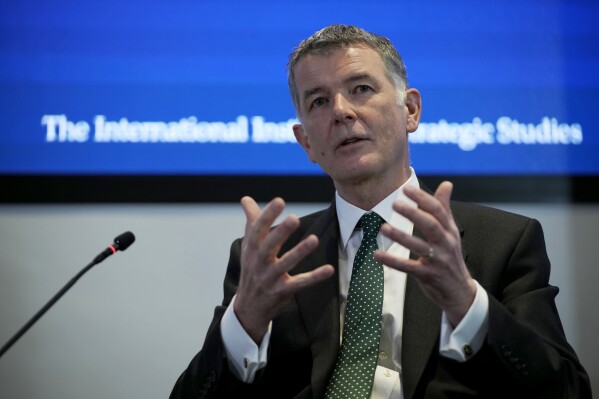 FILE - Richard Moore, the Chief of Britain's Secret Intelligence Service, also known as MI6, answers questions at the International Institute for Strategic Studies, in London, on Nov. 30, 2021. The head of Britain's foreign intelligence agency has thanked Russian state television for encouraging Russians to spy for the UK after it broadcast part of a speech he gave earlier this year. (AP Photo/Matt Dunham)