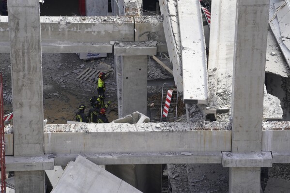 Firefighters arrive at the scene of an accident at a construction site in Florence, Italy, Friday Feb. 16, 2024. An accident at a supermarket construction site in the Italian city of Florence on Friday killed at least one worker and left four others missing, officials said. (Marco Bucco/LaPresse via AP)