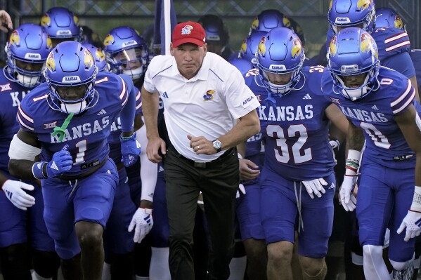 FILE - Kansas head coach Lance Leipold leads his team onto the field before an NCAA college football game against Missouri State Friday, Sept. 1, 2023, in Lawrence, Kan. Kansas football coach Lance Leipold signed an amended contract that increased his overall compensation to more than $40 million through the 2029 season. (APPhoto/Charlie Riedel, File)