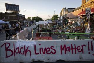 Jersey barriers placed by the city of Minneapolis surround memorials as community members gather in George Floyd Square to demand justice for Winston Boogie Smith Jr., on Monday, June 7, 2021. Smith was fatally shot by members of a U.S. Marshals task force. (AP Photo/Christian Monterrosa)