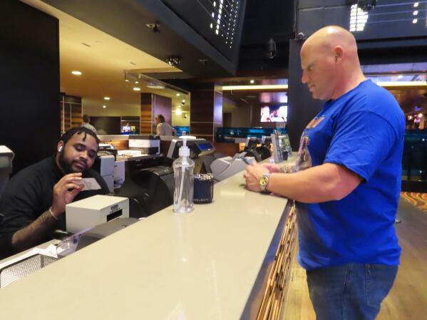 A customer cashes a winning ticket on a New York Mets baseball game in the sports betting lounge at the Tropicana casino in Atlantic City N.J. on Thursday, May 12, 2022. American gamblers have wagered over $125 billion on sports with legal betting outlets in the four years since the U.S. Supreme Court cleared the way for all 50 states to offer legal sports betting; about two thirds currently do. (AP Photo/Wayne Parry)