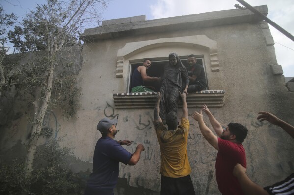 Palestinians evacuate a building hit in the Israeli bombardment of the Gaza Strip in Rafah on Sunday, Oct. 22, 2023. (AP Photo/Hatem Ali)