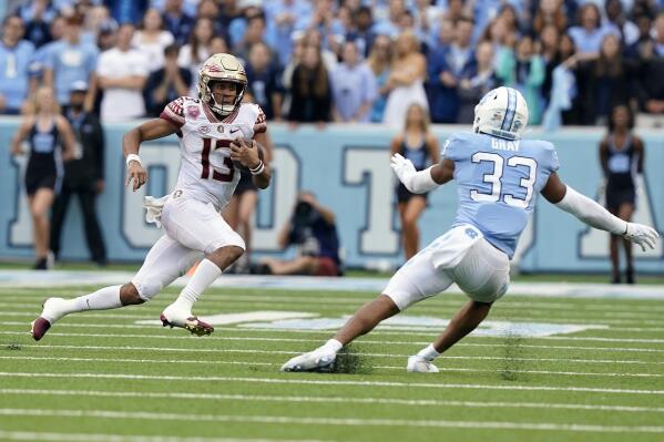Florida State quarterback Jordan Travis (13) runs the ball against North Carolina linebacker Cedric Gray (33) during the first half of an NCAA college football game in Chapel Hill, N.C., Saturday, Oct. 9, 2021. (AP Photo/Gerry Broome)