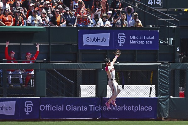 San Francisco Giants' Jung Hoo Lee fails to catch a fly ball hit by Cincinnati Reds' Jeimer Candelario in the first inning of a baseball in San Francisco, Sunday, May 12, 2024. Lee would leave the game after injuring himself during the play. (Jose Carlos Fajardo/Bay Area News Group via AP)