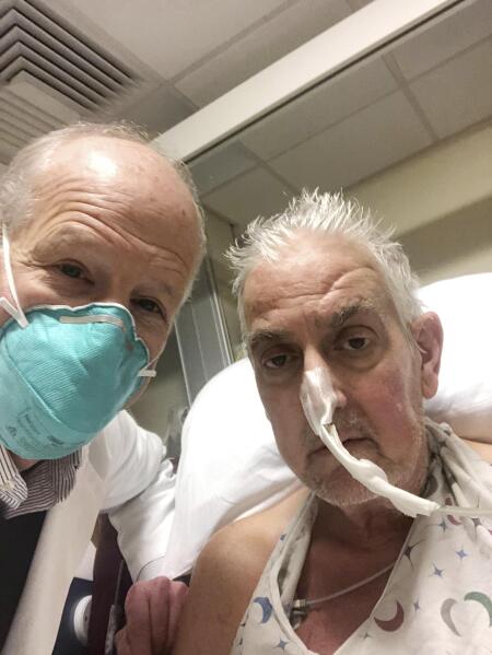 In this photo provided by the University of Maryland School of Medicine, Dr. Bartley Griffith takes a selfie photo with patient David Bennett in Baltimore in January 2022. In a medical first, doctors transplanted a pig heart into Bennett in a last-ditch effort to save his life and the hospital said Monday, Jan. 10, 2022 that he's doing well three days after the highly experimental surgery. (Dr. Bartley Griffith/University of Maryland School of Medicine via AP)