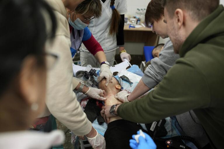 Medical workers unsuccessfully try to save the life of Marina Yatsko's 18 month-old son Kirill, who was fatally wounded by shelling, at a hospital in Mariupol, Ukraine, Friday, March 4, 2022. (AP Photo/Evgeniy Maloletka)