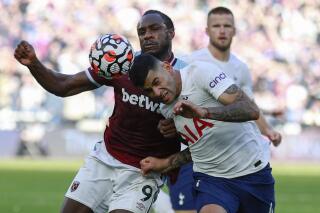West Ham's Michail Antonio, left, challenges for the ball with Tottenham's Cristian Romero during the English Premier League soccer match between West Ham United and Tottenham Hotspur at the London stadium in London, England, Sunday, Oct. 24, 2021. (AP Photo/Ian Walton)