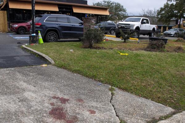 Blood stains and a small section of police tape show the scene where multiple people were injured following an overnight shooting at the Dior Bar & Lounge in Baton Rouge, La., on Sunday, Jan. 22, 2023. (Michael Johnson/The Advocate via AP)