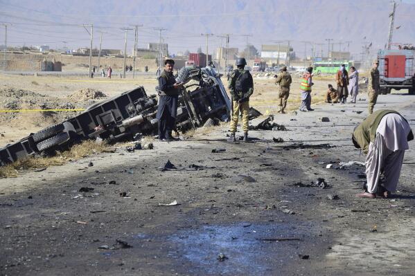 Investigators collect evidence at the site of a suicide bombing on the outskirt of Quetta, Pakistan, Wednesday, Nov. 30, 2022. A suicide bomber blew himself up near a truck carrying police officers on their way to protect polio workers outside Quetta, killing few people and wounding more than 20 others, mostly policemen, officials said. (AP Photo/Arshad Butt)
