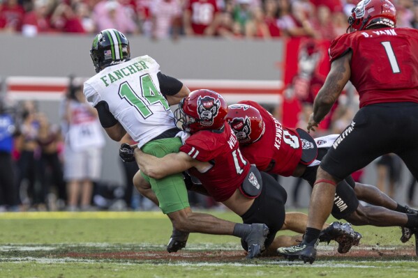 Marshall quarterback Cam Fancher is sacked by North Carolina State's Payton Wilson (11) during an NCAA football game on Saturday, Oct. 7, 2023, at Carter-Finley Stadium in Raleigh, N.C. (Sholten Singer/The Herald-Dispatch via AP)