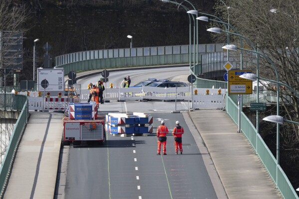 A heavy-duty module loaded with weights drives over the closed Elbe bridge as part of a three-day load test intended to show that the Elbe crossing can be reopened to traffic, in Bad Schandau, Germany, Tuesday April 1, 2025. (Sebastian Kahnert/dpa via AP)