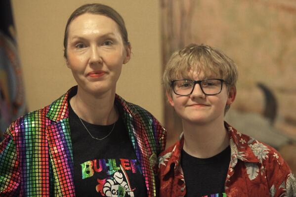 Cat Poland, of Buhler, Kansas, poses with her 13-year-old trans son, Alex, after a day of lobbying by LGBTQ youth and their advocates at the Statehouse, Tuesday, March 28, 2023, in Topeka, Kan. Alex runs cross country and hopes to play baseball next year, and he and his mother are frustrated with multiple bills seeking to roll back LGBTQ rights in the Kansas Legislature, including one to ban transgender athletes from girls' and women's sports. (AP Photo/John Hanna)
