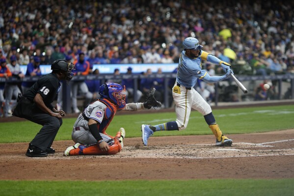 Milwaukee Brewers' Jackson Chourio, right, hits an RBI-single during the fourth inning of a baseball game against the New York Mets, Friday, Sept. 27, 2024, in Milwaukee. (AP Photo/Aaron Gash)