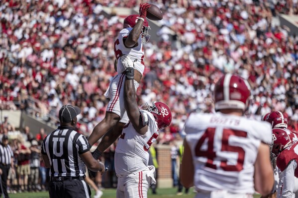 Alabama running back Jam Miller (26) celebrates his touchdown with offensive lineman Tyler Booker (52) during the team's A-Day NCAA college football scrimmage Saturday, April 13, 2024, in Tuscaloosa, Ala. (AP Photo/Vasha Hunt)