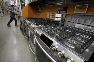 This Oct. 29, 2020 file photo, a passer-by walks past stoves on display at a Home Depot location, in Boston.  Orders to U.S. factories for big-ticket goods shot up 3.4% in January 2021, pulled up by surge in orders for civilian aircraft. A category that tracks business investment posted a more modest gain, the Commerce Department reported Thursday, Feb. 24.  .(AP Photo/Steven Senne, File)
