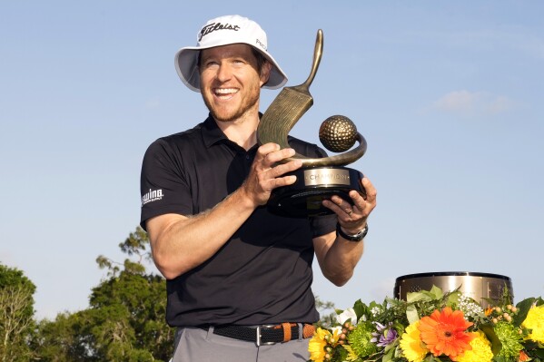 Peter Malnati holds up the trophy after winning the Valspar Championship golf tournament Sunday, March 24, 2024, at Innisbrook in Palm Harbor, Fla. (AP Photo/Chris O'Meara)