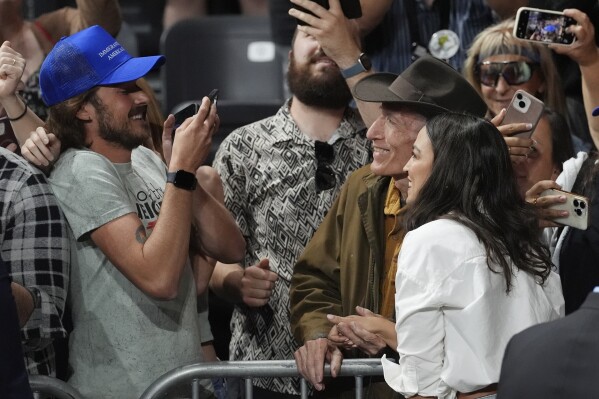 Rep. Alexandria Ocasio-Cortez, D-N.Y., right, takes a photo with a supporter after speaking during a "Fighting Oligarchy" tour event at Arizona State University, Thursday, March 20, 2025, in Tempe, Ariz. (AP Photo/Ross D. Franklin)